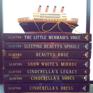 stack of fairy-tale inheritance series books with a titanic model ship on top